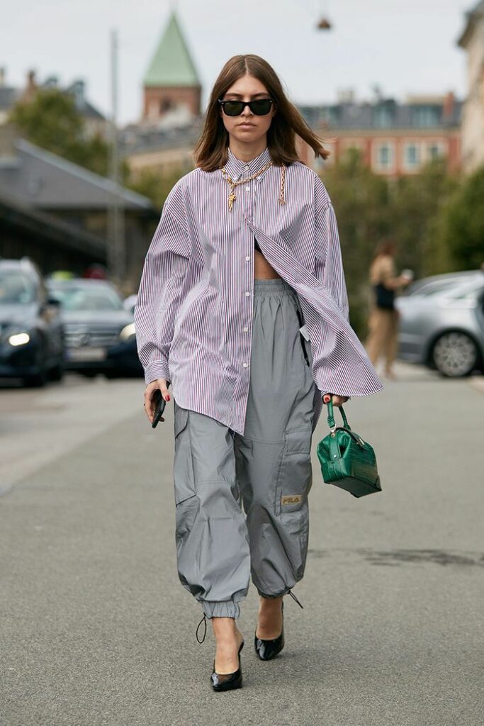 gender-fluid fashion model wearing oversized striped shirt with oversized cargo pants 