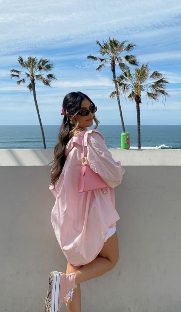 Model in pink oversized shirt with pink bag accessory 