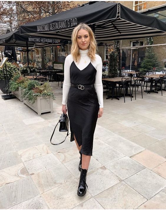 Model in white long sleeve blouse with spagheti strapped knee length black dress