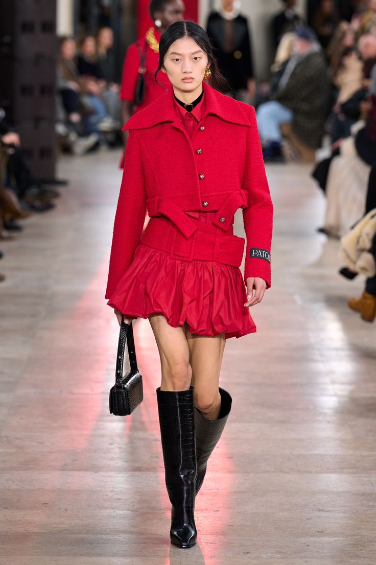 Patou’s Fall/Winter 2025 line featured a stylish ruby red suit consisting of a short wool-blend tweed jacket and a matching belted skirt.