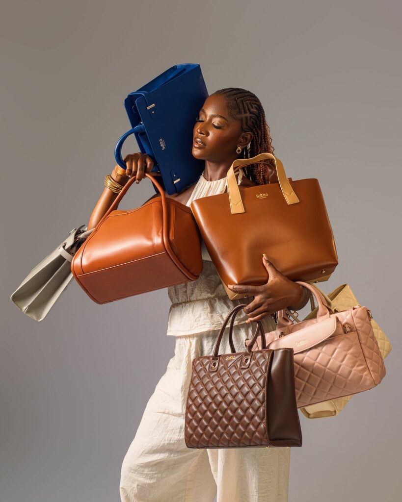 Model holding 5 different handbags