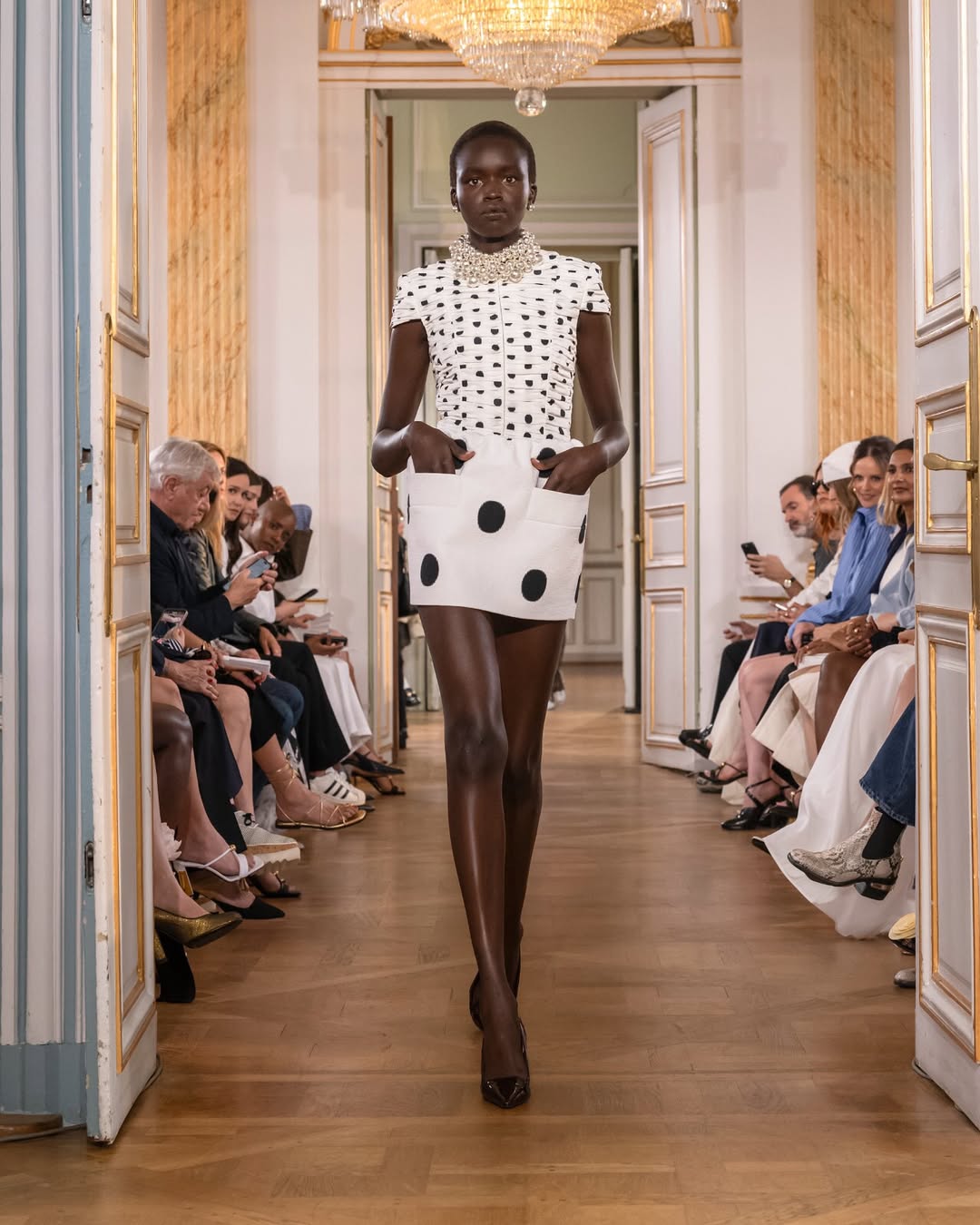 The Patou Spring/Summer 2026 “Joy” collection featured a model strolling down the catwalk wearing a white short-sleeved mini dress embroidered with black polka dots