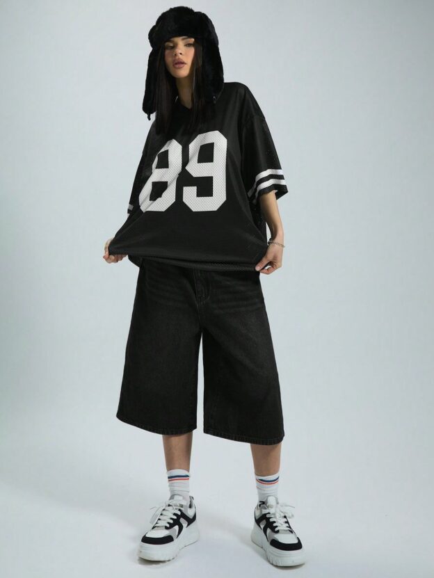 model wearing mountain hat with black graphic short sleeved football jersey and oversized shorts