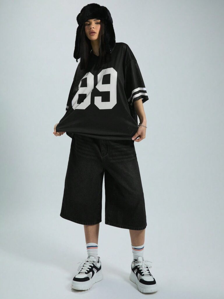 model wearing mountain hat with black graphic short sleeved football jersey and oversized shorts