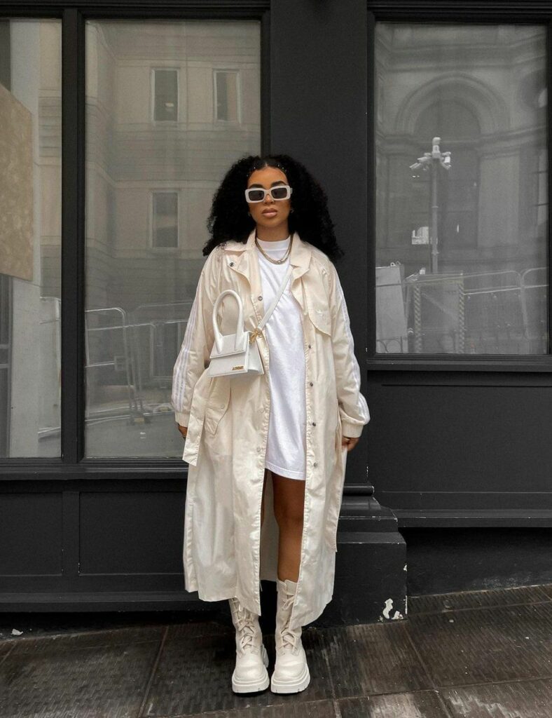 Model wearing full length jacket with oversized T shirt and high chinky boots 