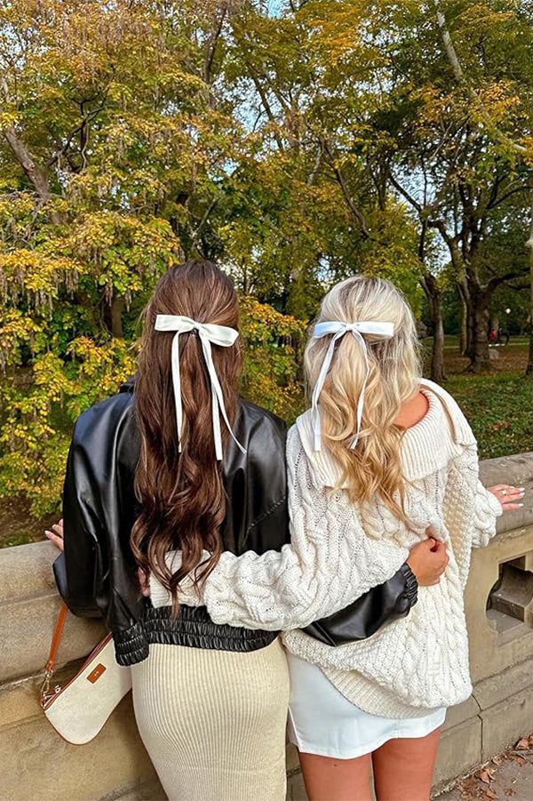 Two models back view wearign pink bows in hair 