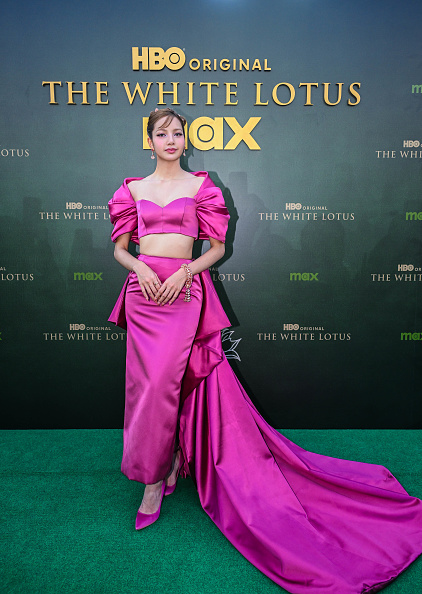 Blackpink Lisa wowed the audience with a neon pink Louis Vuitton two-piece tailored set that included a satin crop top with a sweetheart neckline and ruched puffed short sleeves.