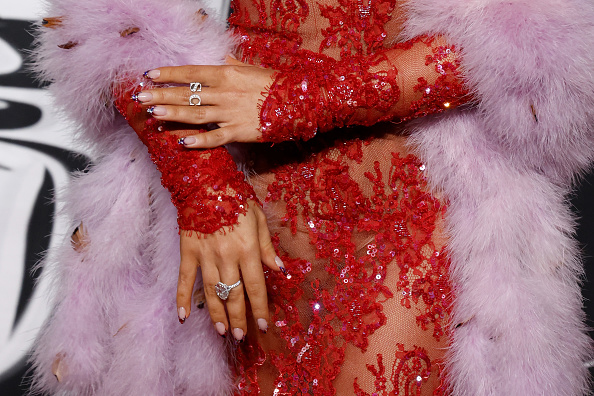 A detailed look at Sabrina Carpenter’s personalized Valentino lace dress adorned with floral decorations and sequins, paired with Tiffany & Co. accessories, at the 2025 MTV Video Music Awards.