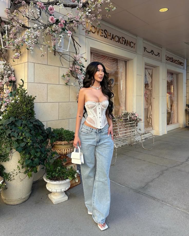 Model with white lace Corset tops and baggy blue jeans 