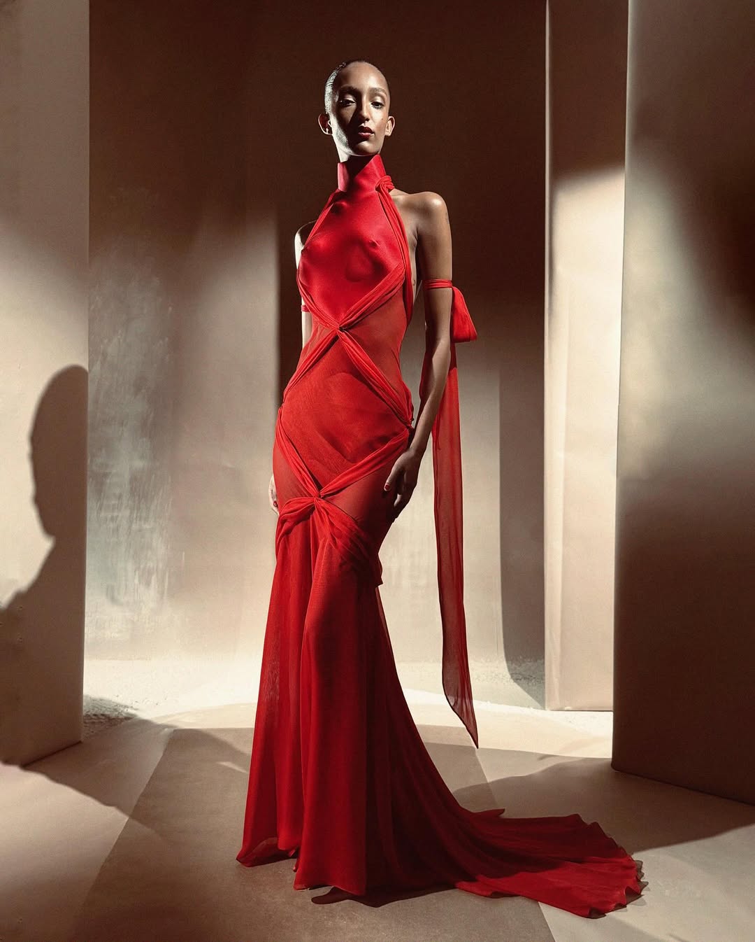 Mona Tougaard wore a bias-cut halter neck dress in double satin and scarlet silk for Schiaparelli Haute Couture’s Fall/Winter 2025/2026 collection, which included a trompe l’oeil bodice and sculpted breasts.