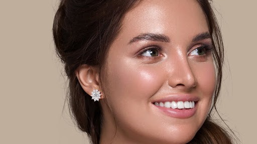 A woman is wearing diamond earrings