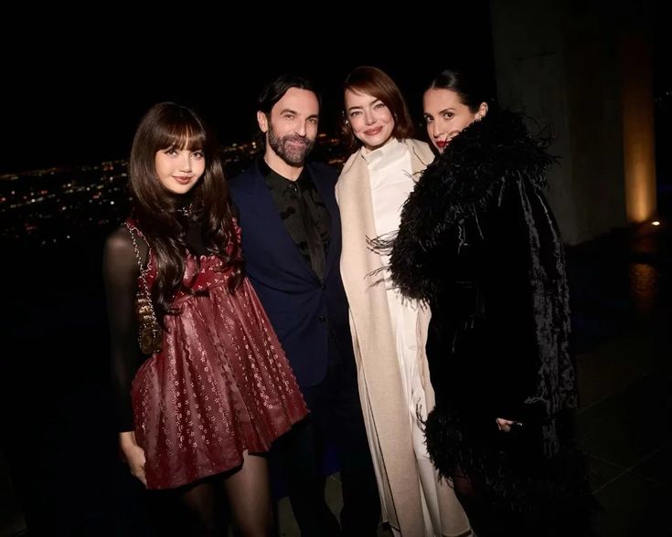 BLACKPINK Lisa attends the Louis Vuitton and W Magazine Intimate Awards Season Dinner alongside Nicolas Ghesquière, Emma Stone, and Sara Moonves, wearing a short dress with a sheer turtleneck top underneath.