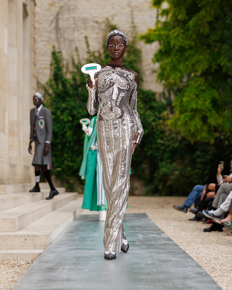 A model walks the runway for Thom Browne Womenswear’s Spring/Summer 2026 collection, dressed in a silver metallic sheer tulle embroidered bodysuit and pencil skirt