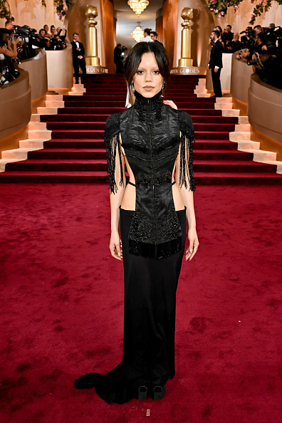 Jenna Ortega looks elegant at the 2026 Golden Globe Awards in a Dilara Findikoglu cutout embroidered gown, Christian Louboutin Cassia satin heels, and Simone Birds Poetry jewelry.