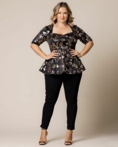 Model in black floral peplum top and black capri pants
