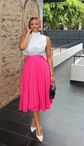 Model in white blouse and pink skirt