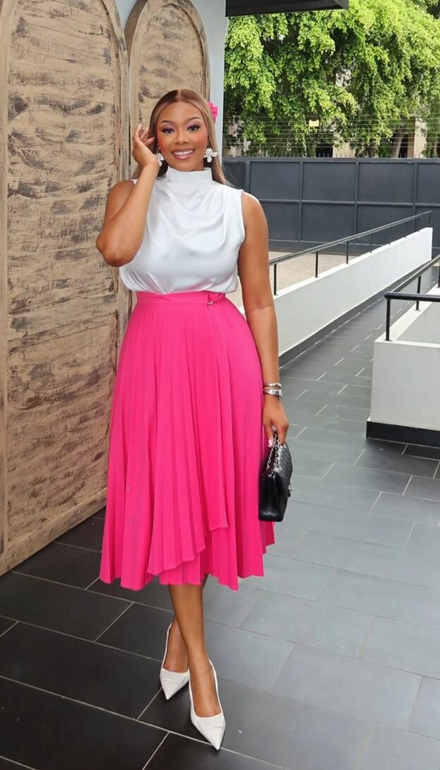 Model in white blouse and pink skirt