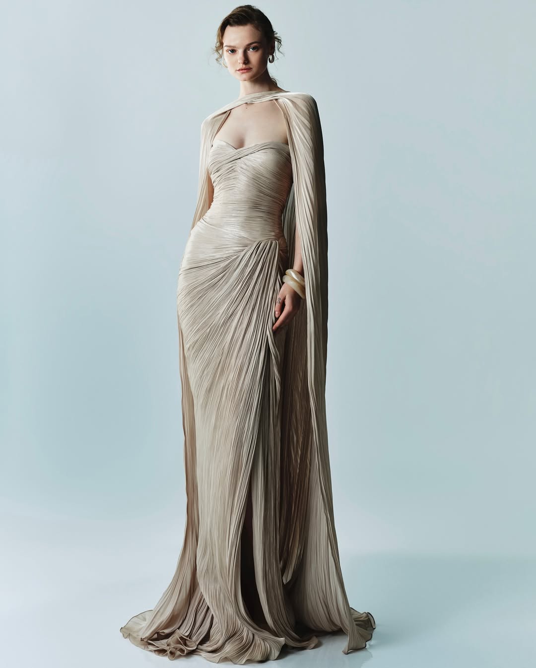 Marmar Halim’s Spring/Summer 2025 collection featured a strapless draped metallic plissé-silk gown and a pleated cape.