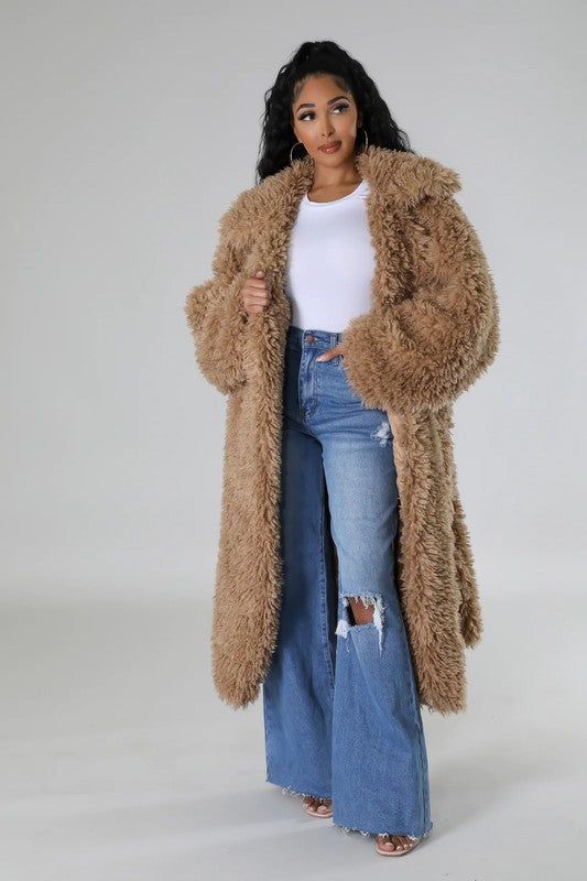 Model in white tee, with torn jeans and full length brown faux fur coat