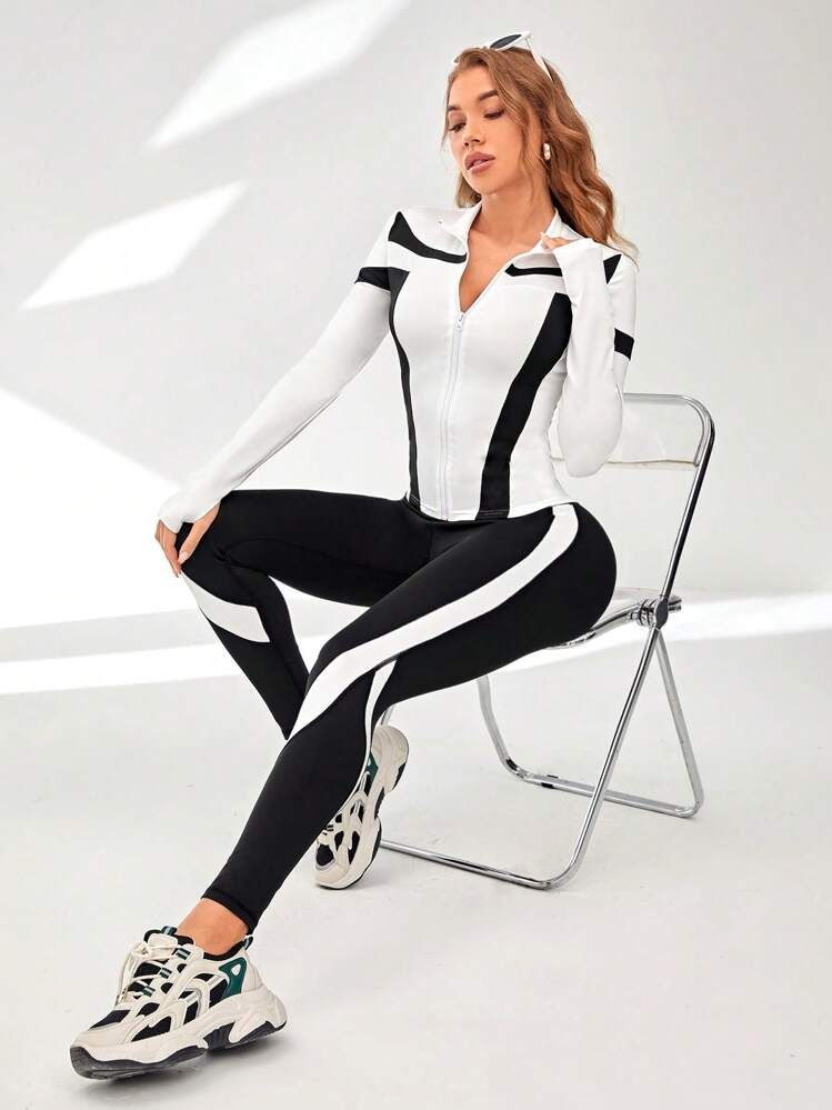 Model in 2 piece gym set blacn and white with white jacket type top