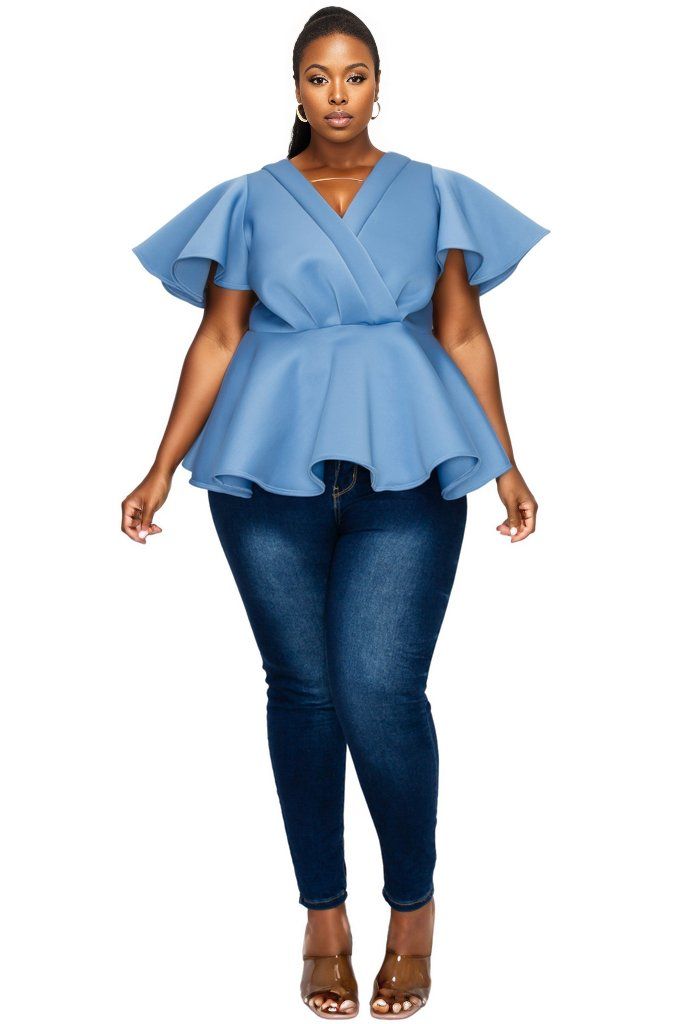 plus-size model in blue jeans and blue peplum top 