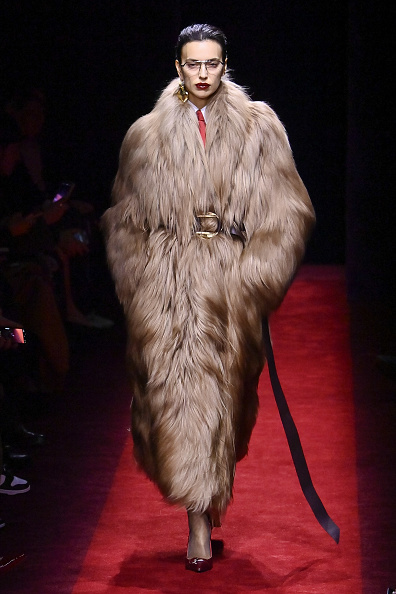 Irina Shayk, a Russian fashion model and actress, walks the runway at the Ferrari Fall/Winter 2025/2026 “Officina” (workshop) wearing a long faux fur coat.