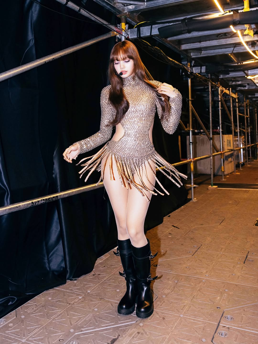Blackpink Lisa is wearing a golden long-sleeved metallic turtleneck bodysuit embellished with little round dazzling ornaments all over the body