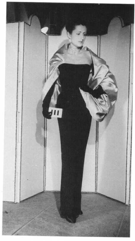 During Cristóbal Balenciaga’s 1950s haute couture collection, a fashion model was photographed wearing a two-tone black velvet ensemble complemented by a white back satin cape.