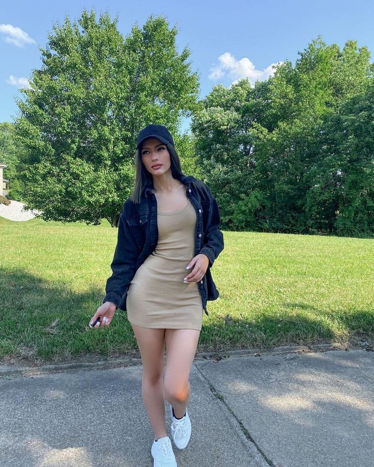 Model in beige bodycon dress with denim jacket 