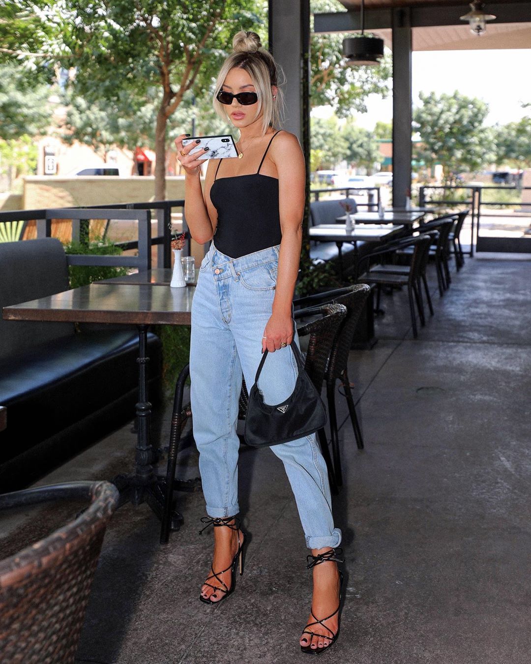 788a0dfa62daafbcf695adb2b541ba28 | Fashonation A woman is wearing a cami top with denim jeans paired with a black square-toe heel sandals
