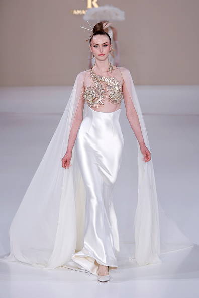 BB Jean walked the Tamara Ralph Haute Couture Spring/Summer 2026 “La Lumière Dorée” (The Golden Light) ready-to-wear collection at Pavillon Cambon, wearing a buttercream silk chiffon cape with a gold crystal peacock feather top underneath and an off-white silk double satin corseted skirt, which actress and singer Suki Waterhouse also wore to the 2026 Vanity Fair Oscar Party.
