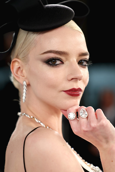 Anya Taylor-Joy attended the 2026 Vanity Fair Oscar Party wearing a black vintage John Galliano bodysuit, a matching Stephen Jones Millinery satin hat, Tiffany & Co. Bird on a Rock Wings drop earrings in platinum with diamonds, and high jewelry 5-carat diamond rings.