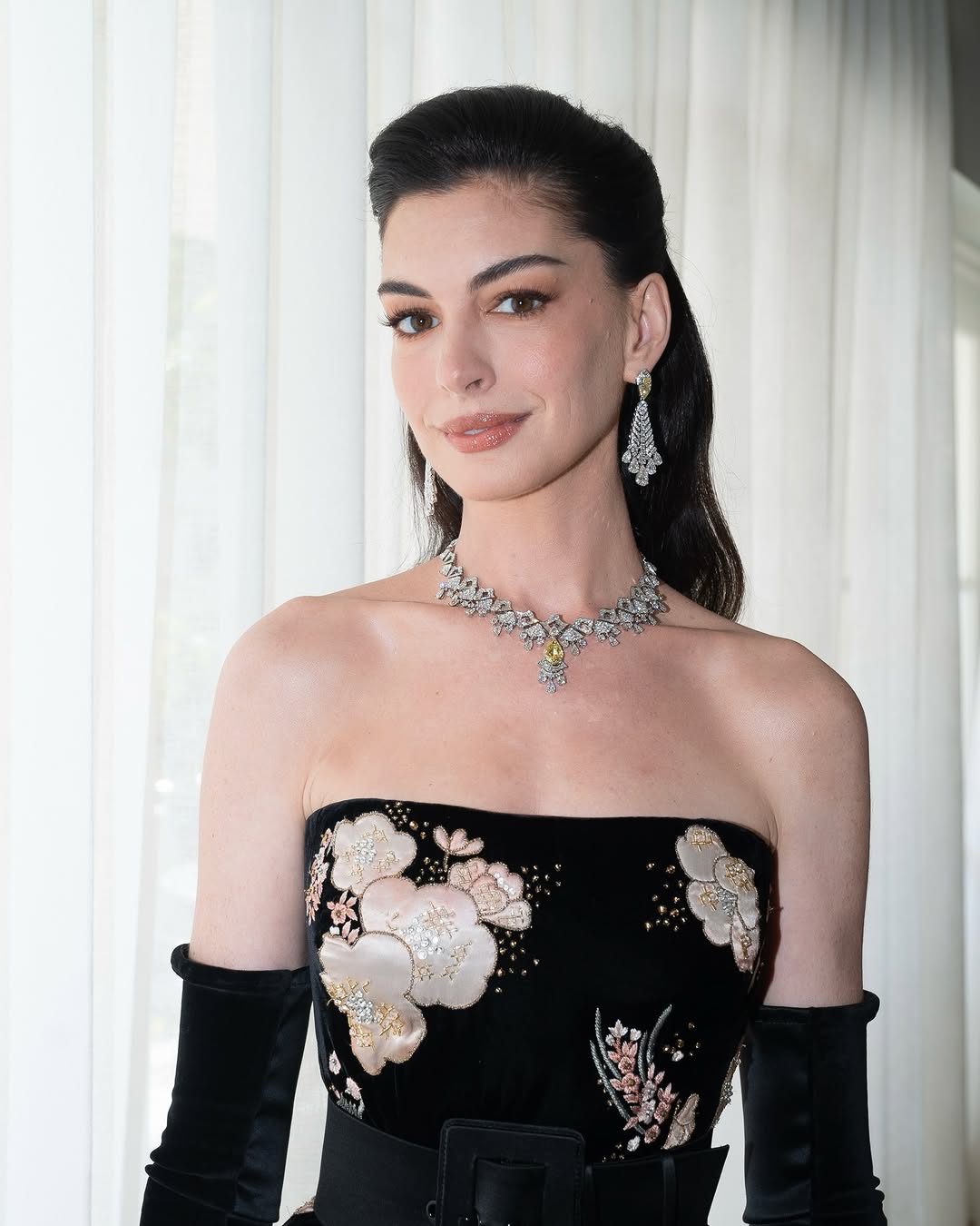 Anne Hathaway wore a strapless velvet gown embellished with floral embroidery from the Valentino Haute Couture Spring/Summer 2026 collection, titled Specula Mundi, complemented by drop diamond earrings and the Starlight necklace from Bulgari’s Eclettica High Jewelry collection.