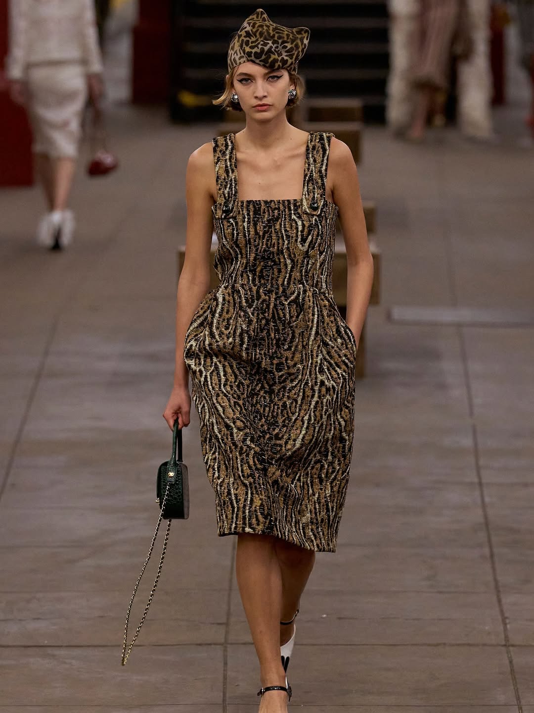 Rolf Schrader walked through the Bowery subway station wearing a leopard-print midi dress and matching headpiece during the Chanel Métiers d’Art 2026 collection.
