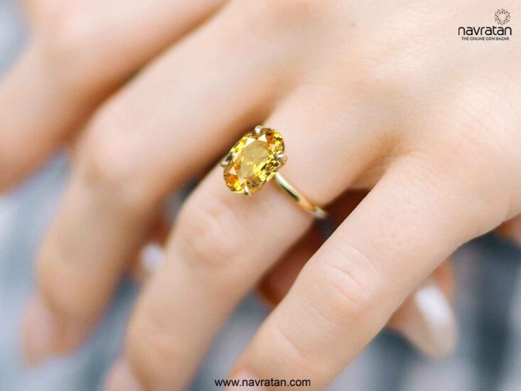 hand wearing yellow sapphire ring