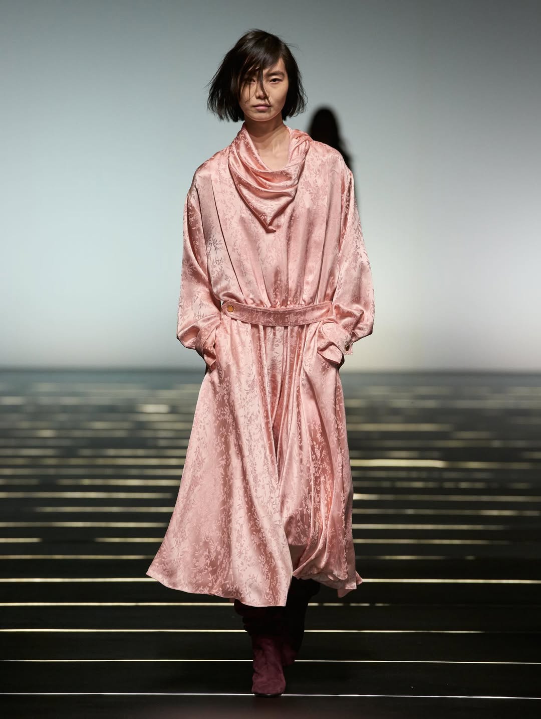 the Alberta Ferretti Fall/Winter 2026/2027 collection debuted a long-sleeved jacquard midi dress with a draped handkerchief collar that created a scarf illusion around the neck