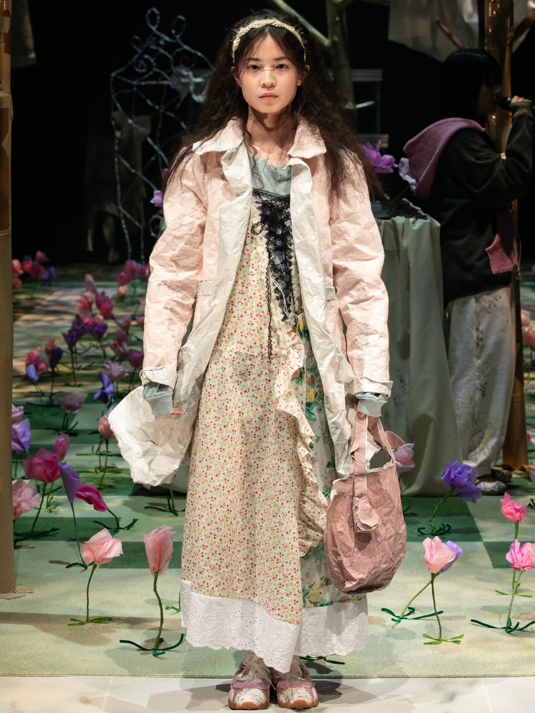 The Yusho Kobayashi Fall/Winter 2026 ready-to-wear collection titled “Void” during Tokyo Fashion Week showcased a pink jacket with a multicolored floral midi dress underneath.