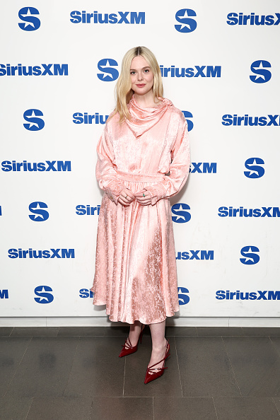 Elle Fanning wore a magnificent pale pink silk satin jacquard dress featuring a long-sleeved bodice and a draped handkerchief collar.