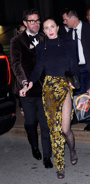 Emily Blunt was seen walking hand in hand with her husband, John Krasinski, at the “The Devil Wears Prada 2” New York City premiere after-party, clad in a Balmain turtleneck bodysuit and sheer gold floral jacquard thigh-high split maxi skirt with Juju Vera Nani gold drop earrings.