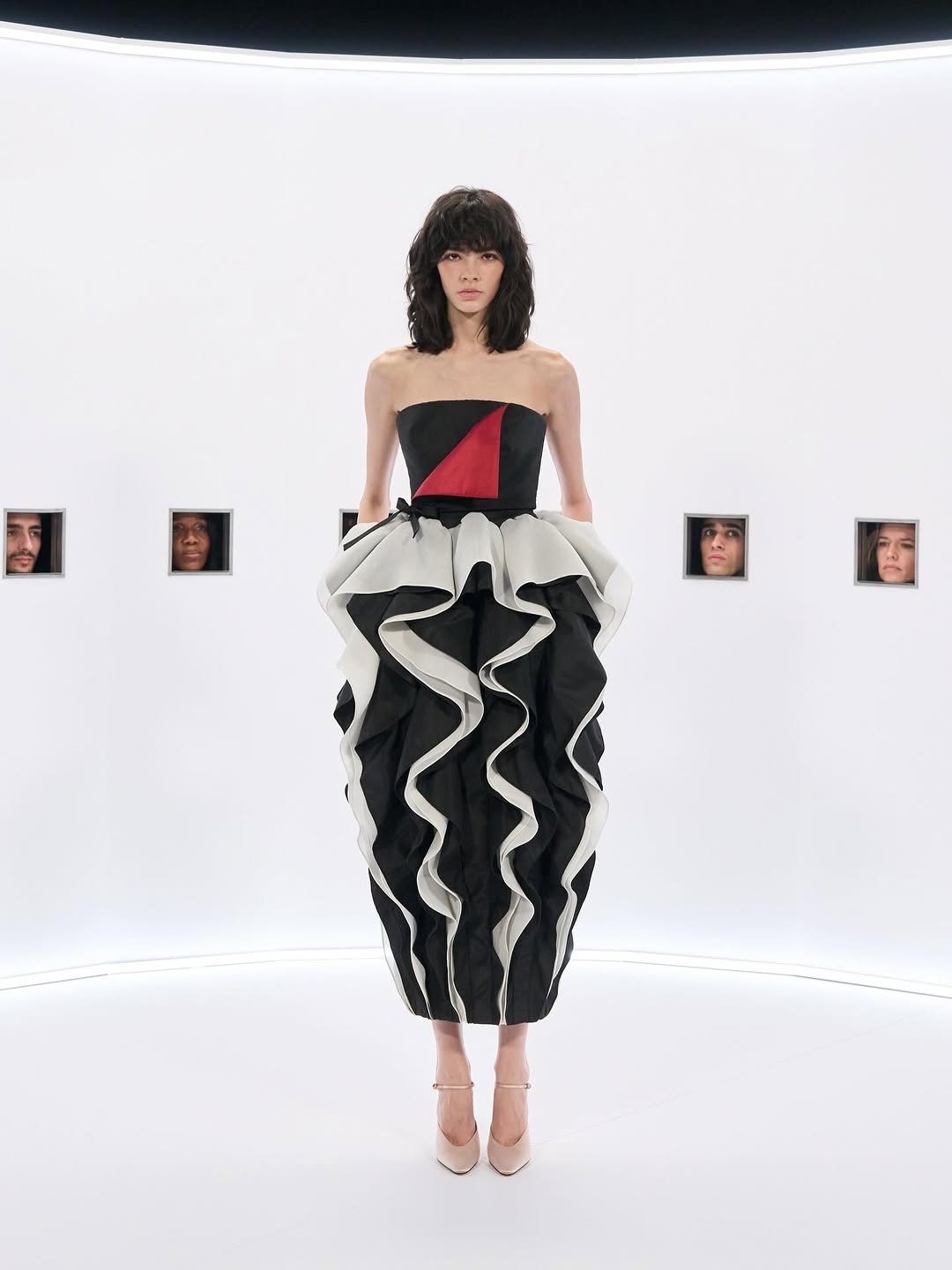 The Valentino Haute Couture Spring/Summer 2026 “Specula Mundi” collection included a strapless silk gown with a draped bodice and a ruffled midi skirt.