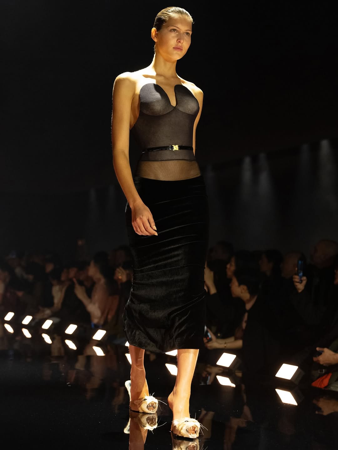 BLACKPINK Jennie attended the 2026 Time100 Gala in a Schiaparelli strapless plunging-neck dress from their “The Sphinx” womenswear Fall/Winter 2026/2027 collection, which featured a bustier corset toile fastened with a thin patent leather belt with a golden buckle and a velvet midi skirt with a stripe of sheer tulle that revealed her hips.