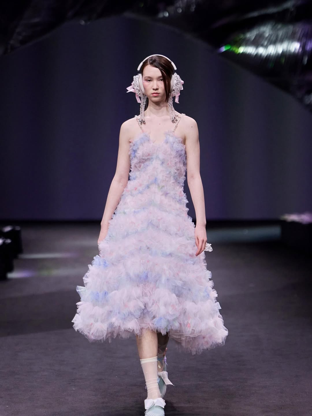 During Shanghai Fashion Week, Susan Fang’s “Air-Infinity” Fall/Winter 2026/2027 collection had a tiered midi dress with embroidered headphones with large, lovely bows and dangling crystal-like drop earrings