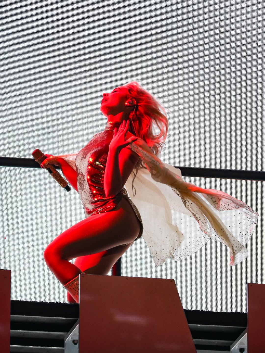 Sabrina enhanced her 2026 Coachella performance ensemble with semi-sheer pantyhose, white knee-high leather boots, and her iconic Maison Raksha diamond-initial ring.