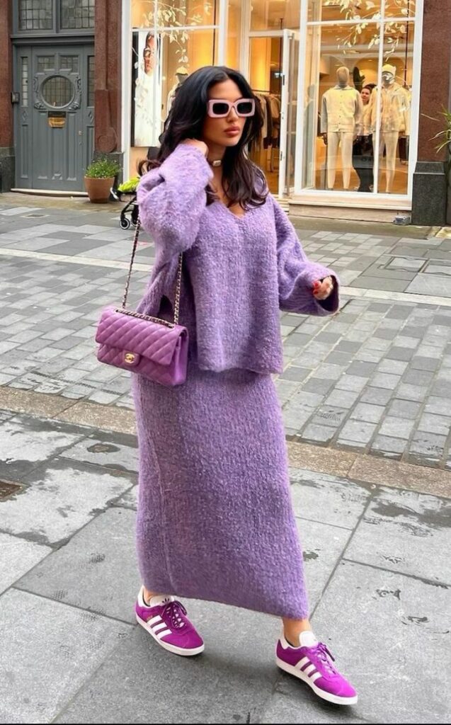 Model in purple sweater top and long skirt 