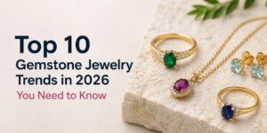 Hero image for an article: the title 'Top 10 Gemstone Jewelry Trends in 2026 You Need to Know' with gold rings, pendant, and earrings on a stone background.