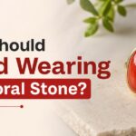 Question: Who should avoid wearing red coral stone? text on left with a red gemstone ring on a beige surface on the right.
