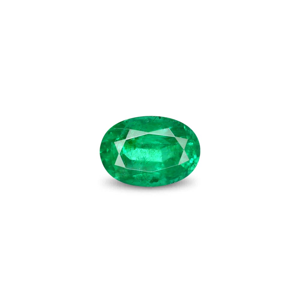 Oval-cut emerald stone with faceted surface on a white background