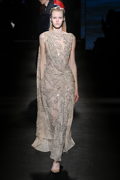Model Malin Rudnick walked the runway at the Balenciaga Fall/Winter 2026-2027 “ClairObscur” show in a beige sheer caped gown encrusted with crystals, sequins, and beads, which Daisy Edgar-Jones wore on the red carpet of the “Fjord” Cannes Film Festival premiere.