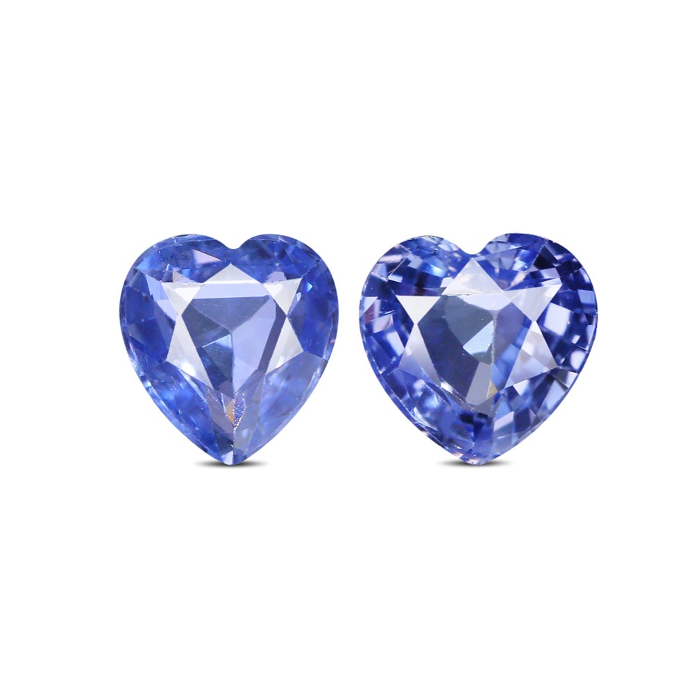 Birthstones - Two blue heart-shaped gemstones placed side by side on a white background, showcasing facets and shine.