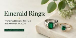 Emerald rings on a beige surface beside greenery; promotional banner for 2026 ring designs.